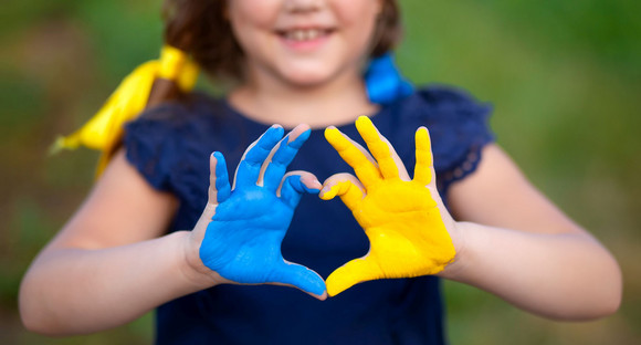 Love Ukraine concept. Little girl show hands in heart form painted in Ukraine flag color - yellow and blue. Independence day of Ukraine, Flag, Constitution day Education, school, art painitng concept