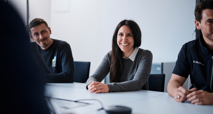 Lächelnde Lehrkräfte an einem Besprechungstisch