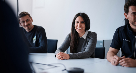 Lächelnde Lehrkräfte an einem Besprechungstisch