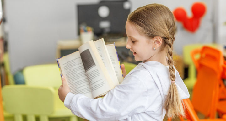 Ein Mädchen liest aus einem Buch vor.