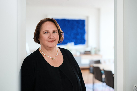 Ministerin Offizielle Fotos Kultusministerin Theresa Schopper Ministerin Schopper lehnt an einem Türrahmen, im Hintergrund ist ihr Büro zu sehen