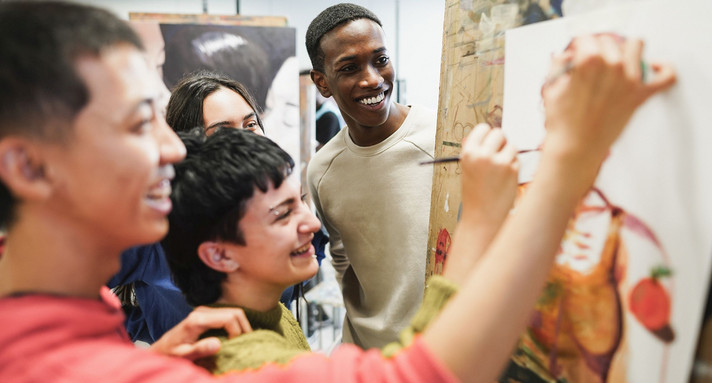 Multiracial students painting inside art room class at university - Focus on african man face Multiracial students painting inside art room class at university - Focus on african man face