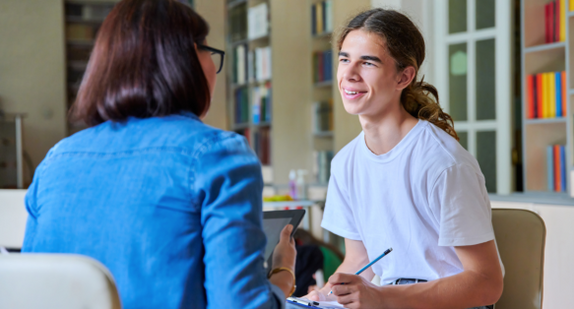 älterer Schüler mit Psychologin beim Beratungsgespräch