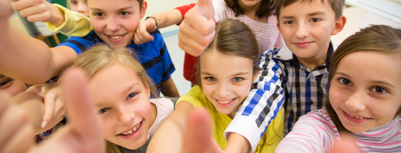 Gruppe von Schulkindern streckt den Daumen nach oben