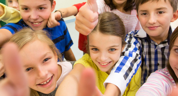 Gruppe von Schulkindern streckt den Daumen nach oben