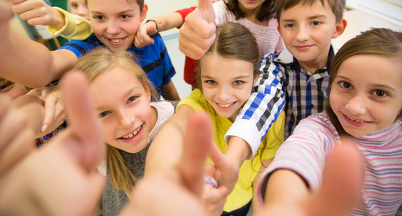 Gruppe von Schulkindern streckt den Daumen nach oben