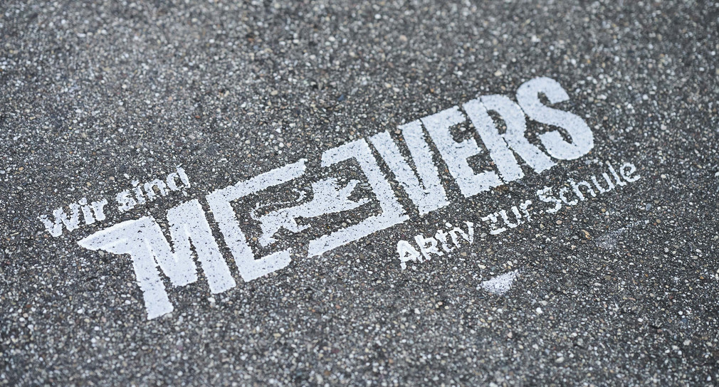 Auf grauem Asphalt steht in weißer Schrift "Movers".