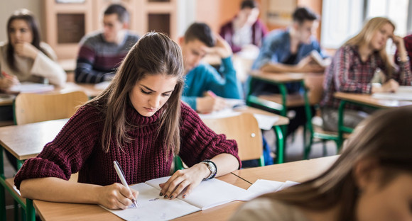 Jugendliche Schülerinnen schreiben einen Test im Klassenraum