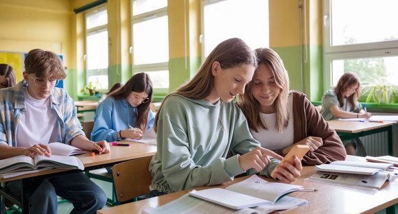 Schulklasse mit jugendlichen Schülerinnen und Schüler von vorn und seitlich fotografiert