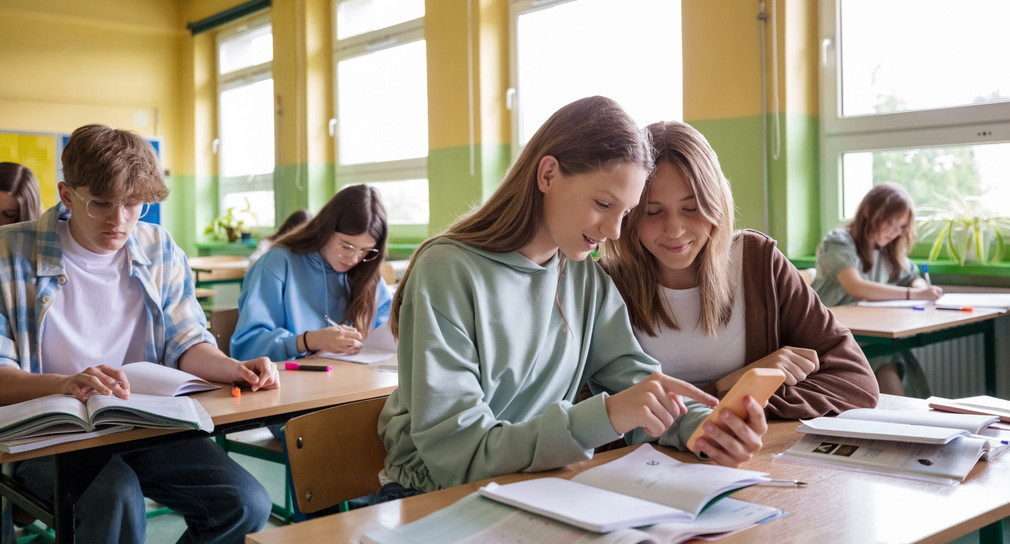 Schulklasse mit jugendlichen Schülerinnen und Schüler von vorn und seitlich fotografiert