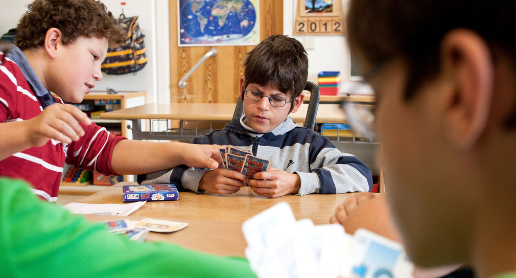 Schüler in Inklusionsklasse spielen Karten