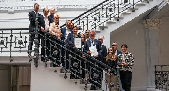 Mehrere Menschen stehen nebeneinander auf einer Treppe. 