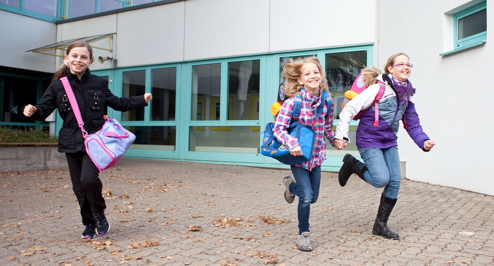 Grundschüler verlassen fröhlich die Schule