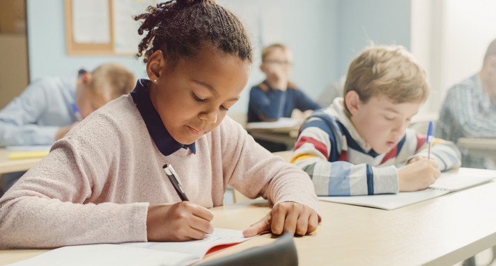 Klassenraum mit diverser Gruppe von Kindern, die einen Test schreiben
