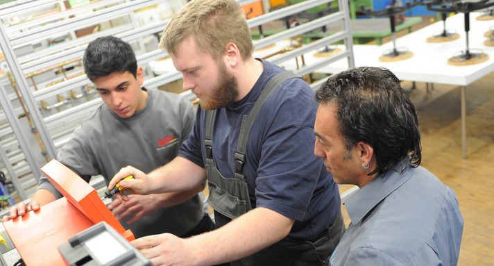 Schüler mit Ausbildern in der Werkstatt