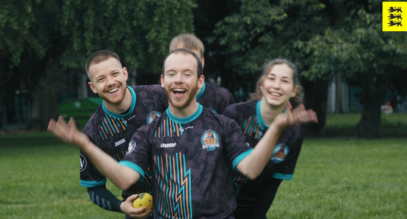 Vier personen in Sporttrikots stehen hintereinander.
