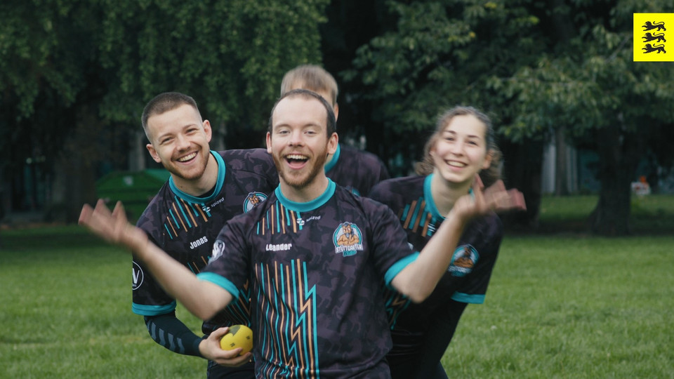 Vier personen in Sporttrikots stehen hintereinander.