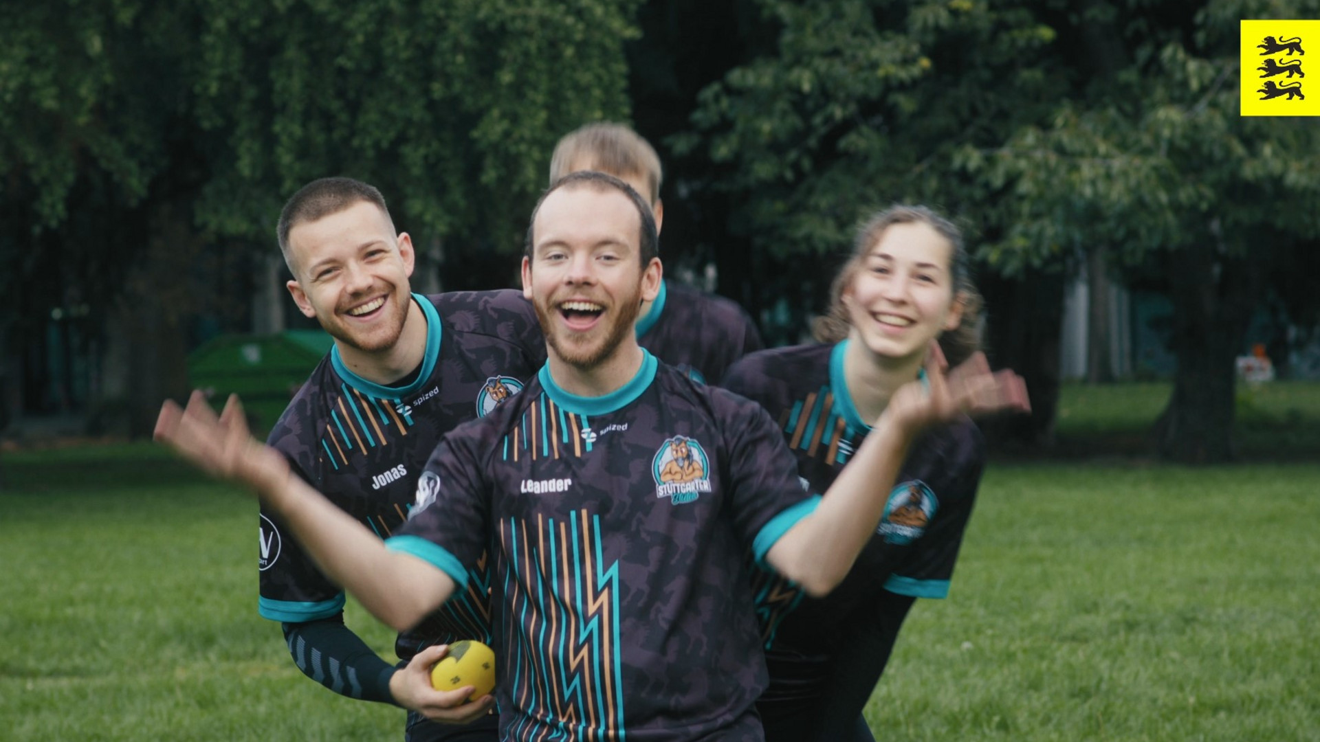 Vier personen in Sporttrikots stehen hintereinander. 