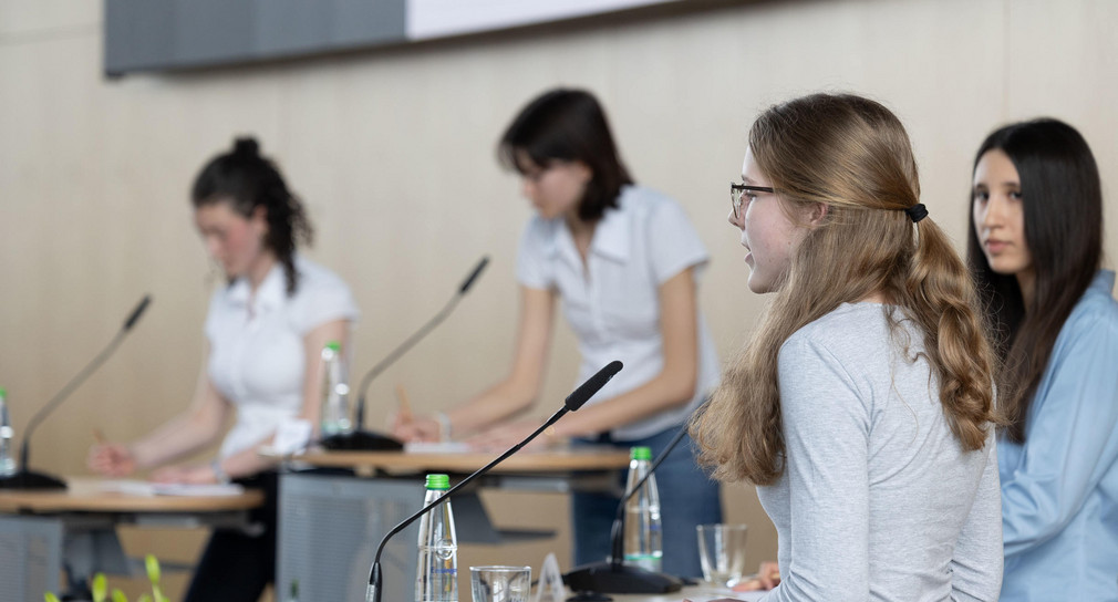 Schülerinnen an Redepulten mit Mikrofonen