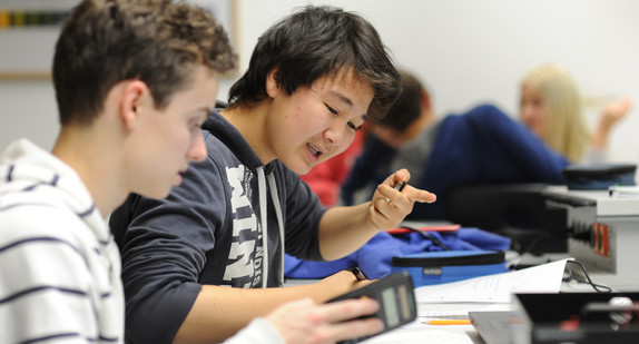 Schüler, die nebeneinander sitzen, rechnen