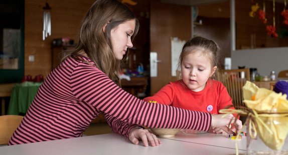 Erzieherin und Kind beim Puzzeln