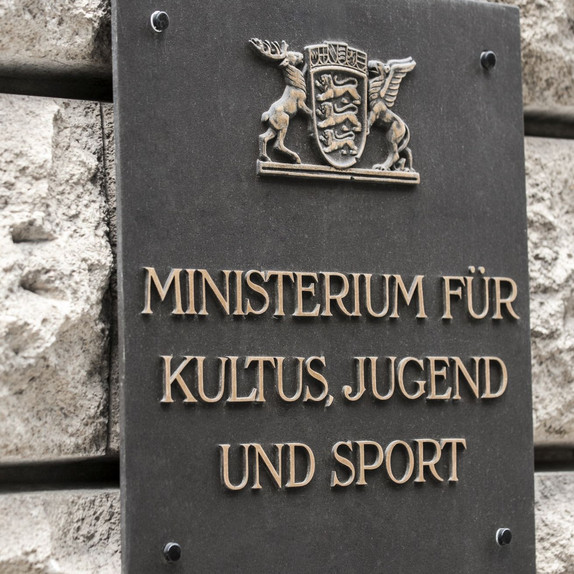 Das Wappen des Landes Baden-Württemberg auf einem Schild, darunter der Schriftzug "Ministerium für Kultus, Jugend und Sport" 