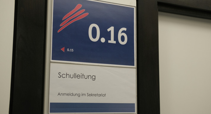 Ein blaues Schild mit der Aufschrift "Schulleitung". 