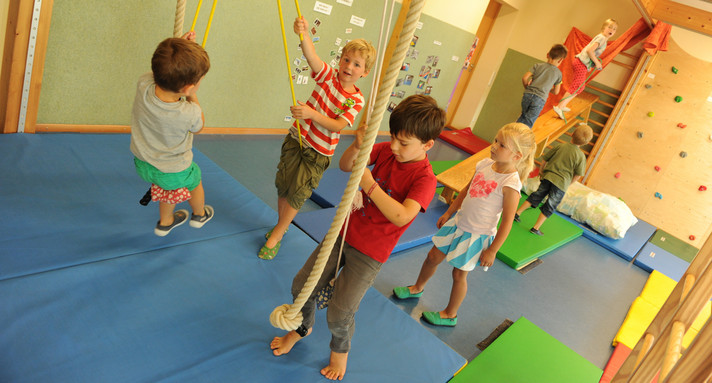 Mehrere Kinder spielen an einem Klettergerüst. 