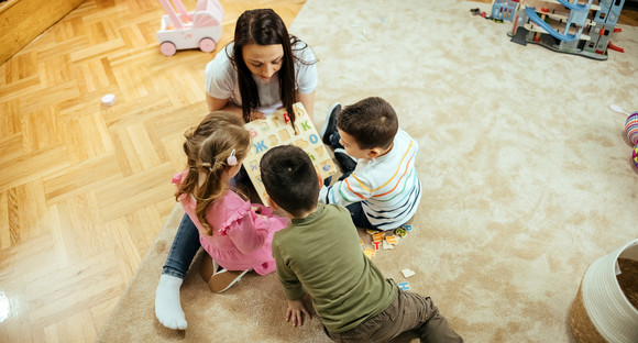 Erzieherin mit gemischter Kindergruppe um sich