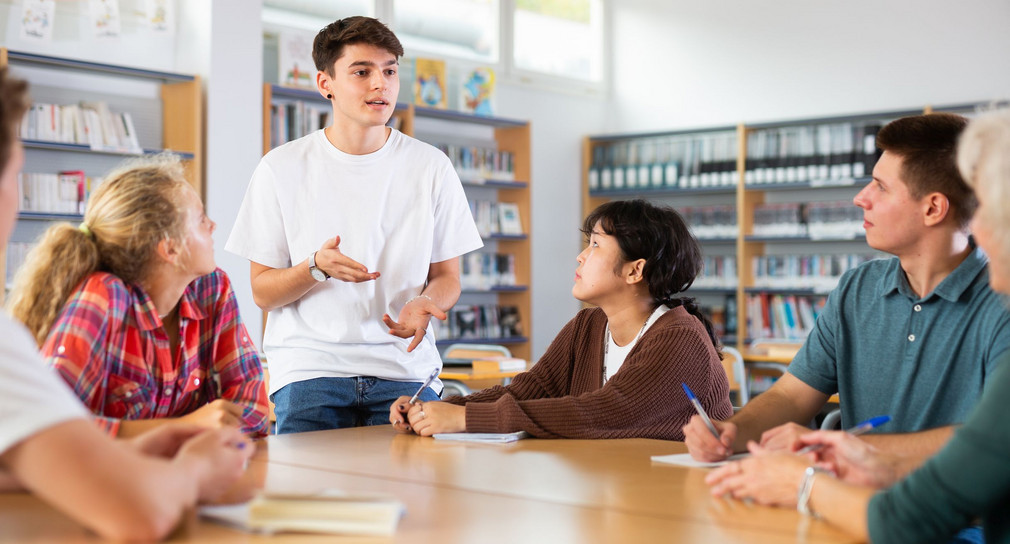 Group of schoolchildren in the school library, discussing something