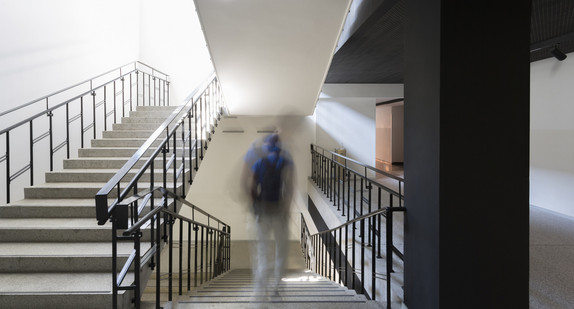 Leere Schultreppe, nur ein Schüler in Unschärfe geht die Treppe runter