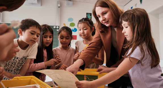 Schülerinnen und Schüler mit Staatssekretärin Boser in einem Klassenzimmer