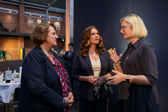 Sportministerkonferenz Sportministerkonferenz 8. und 9. Mai 2025 in Chemnitz Drei Frauen stehen einander gegenüber und sprechen miteinander.