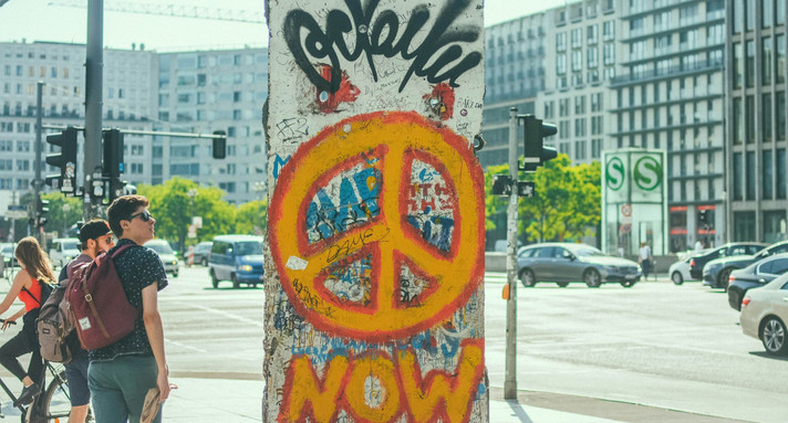 Stück der Berliner Mauer mit einem Peace-Zeichen aufgemalt. Foto: Dogukan Sahin/Unsplash.com.