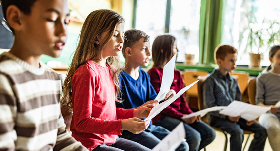 Singende Kinder in einem Schulraum