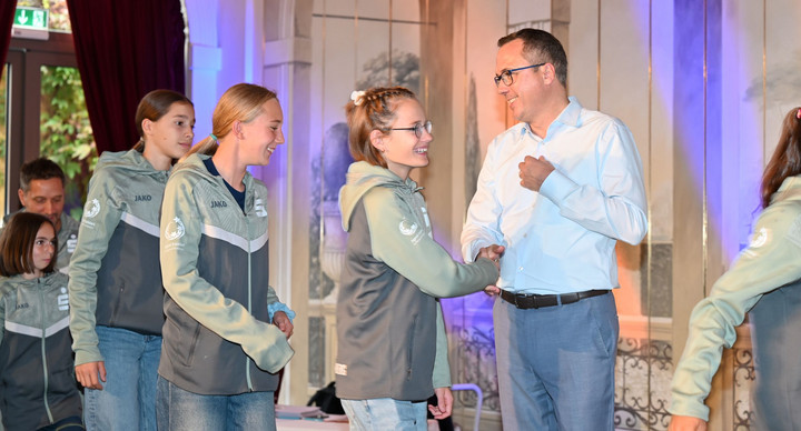 Staatssekretär Andreas Deuschle MdL schüttelt Schülerinnen die Hand. 