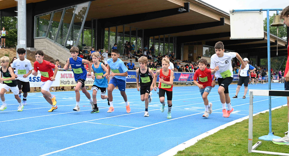 Rennende Kinder in Sportkleidung in einem Stadion