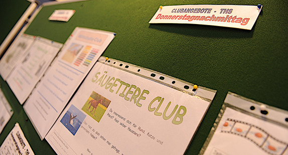 Auf einer grünen PIN-Tafel sind Freizeitangebote bzw. Clubangebote für den Donnerstagnachmittag einer Gemeinschaftschule angeheftet.